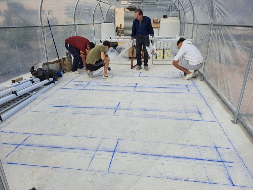 27. Alumnos y profesores de Edificación y Obra Civil replanteando el sistema de canales y mesa de cultivo NFT